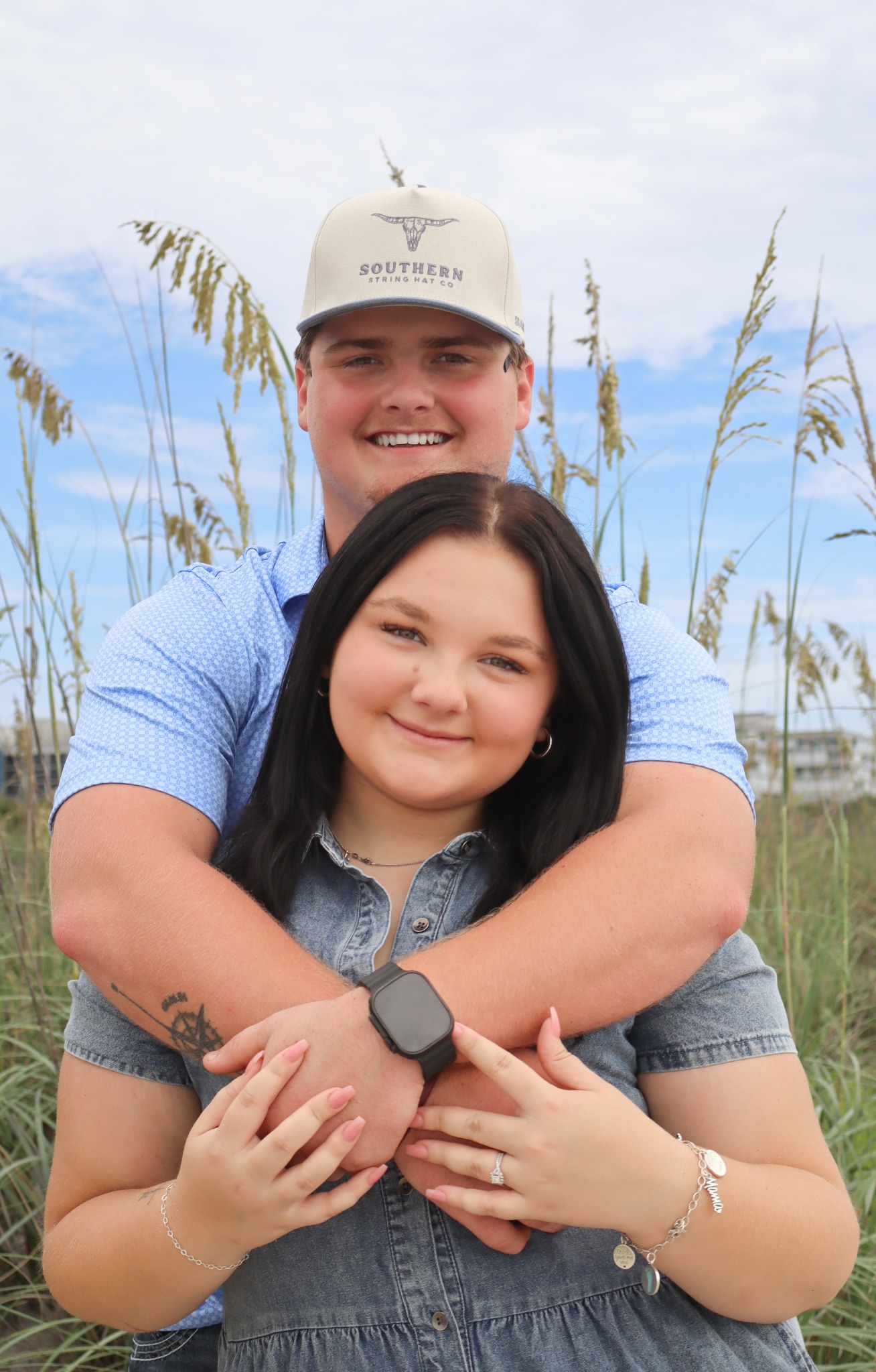 Couple embracing among beach grasses
